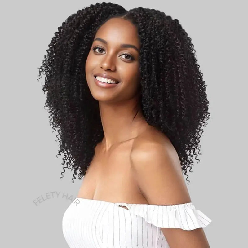 Black woman smiling, wearing afro kinky clip-in extensions.
